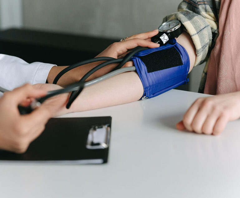 A person having their blood pressure measured with a cuff.