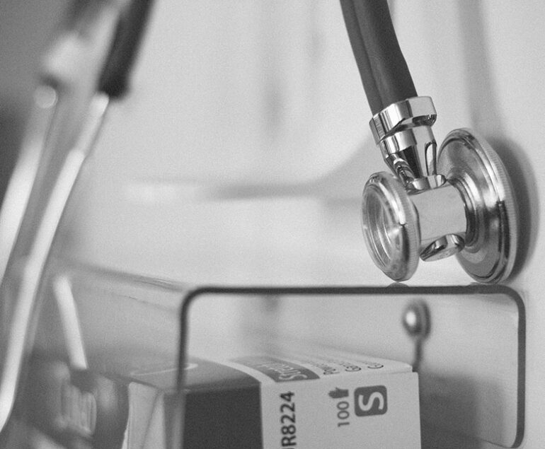 Close-up of a stethoscope and medical equipment in a clinical setting.