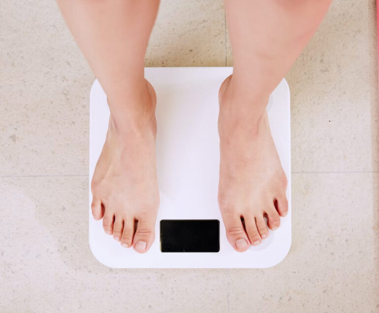 Bare feet standing on a digital bathroom scale.